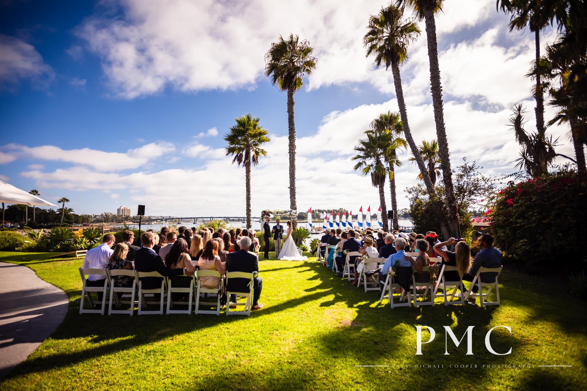 A summer wedding ceremony takes place beside Mission Bay at Paradise Point Resort and Spa.