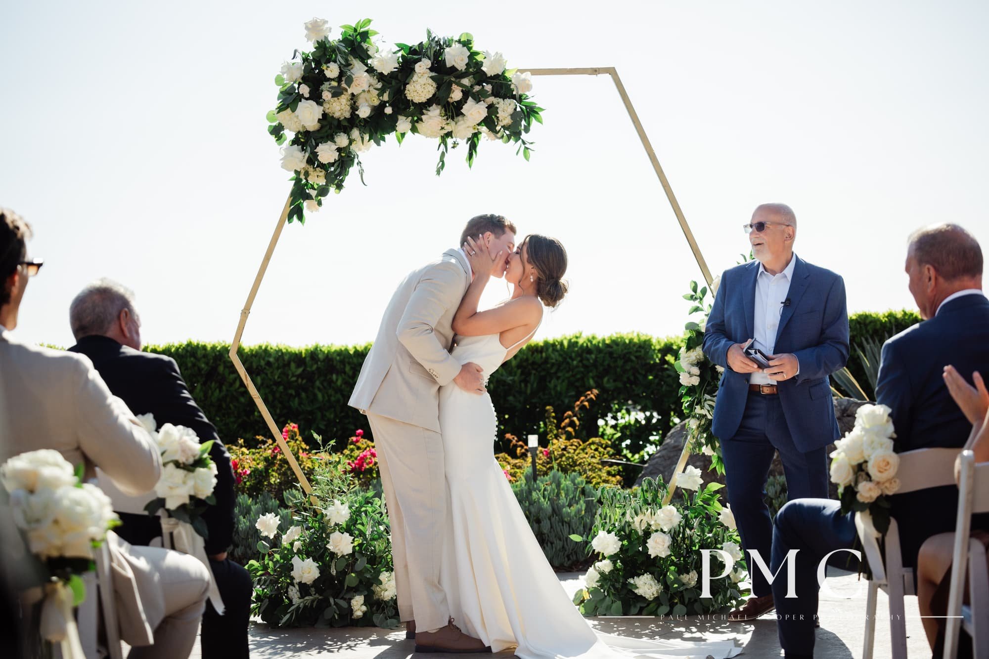 A bride and groom share a passionate first kiss at their sunny wedding ceremony at the Hyatt Regency Mission Bay Resort.