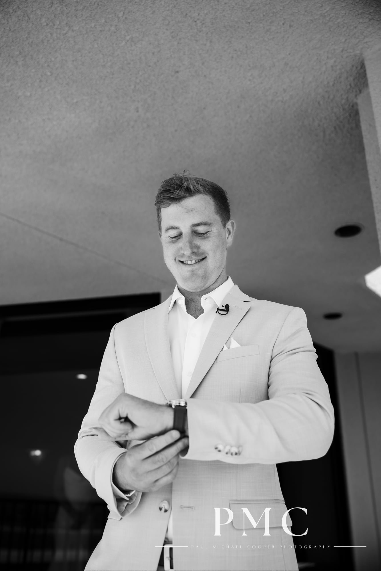 A groom adjusts his watch as he gets ready for his wedding on the balcony of the Hyatt Regency Mission Bay.