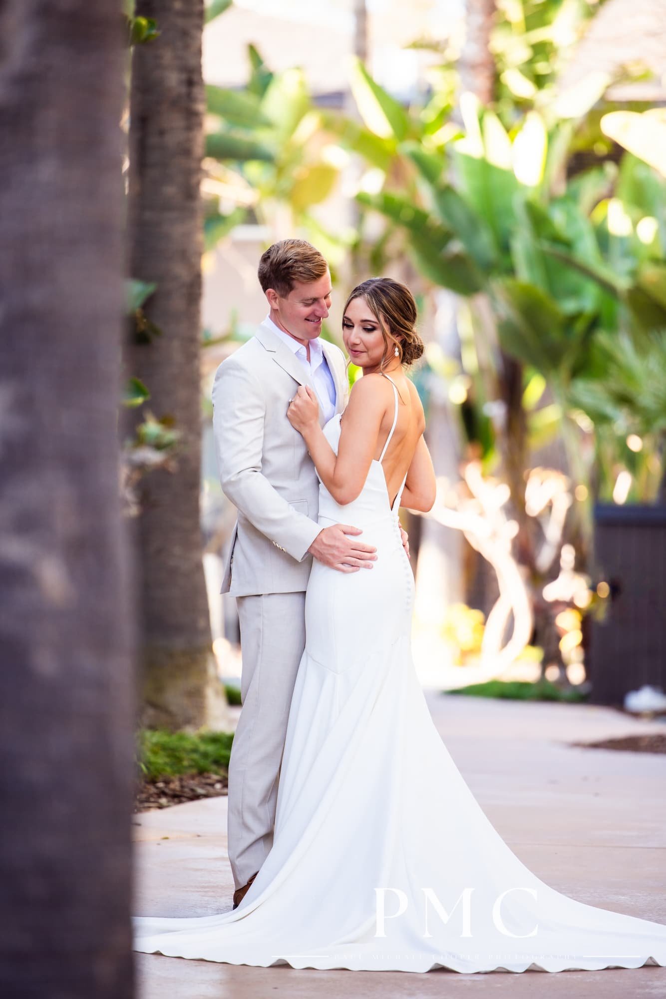 A bride and groom embrace each other in the garden area of the Hyatt Regency Mission Bay Resort.