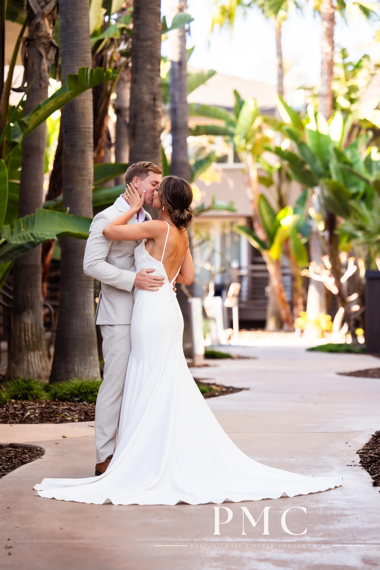 A bride and groom embrace each other in the garden area of the Hyatt Regency Mission Bay Resort.