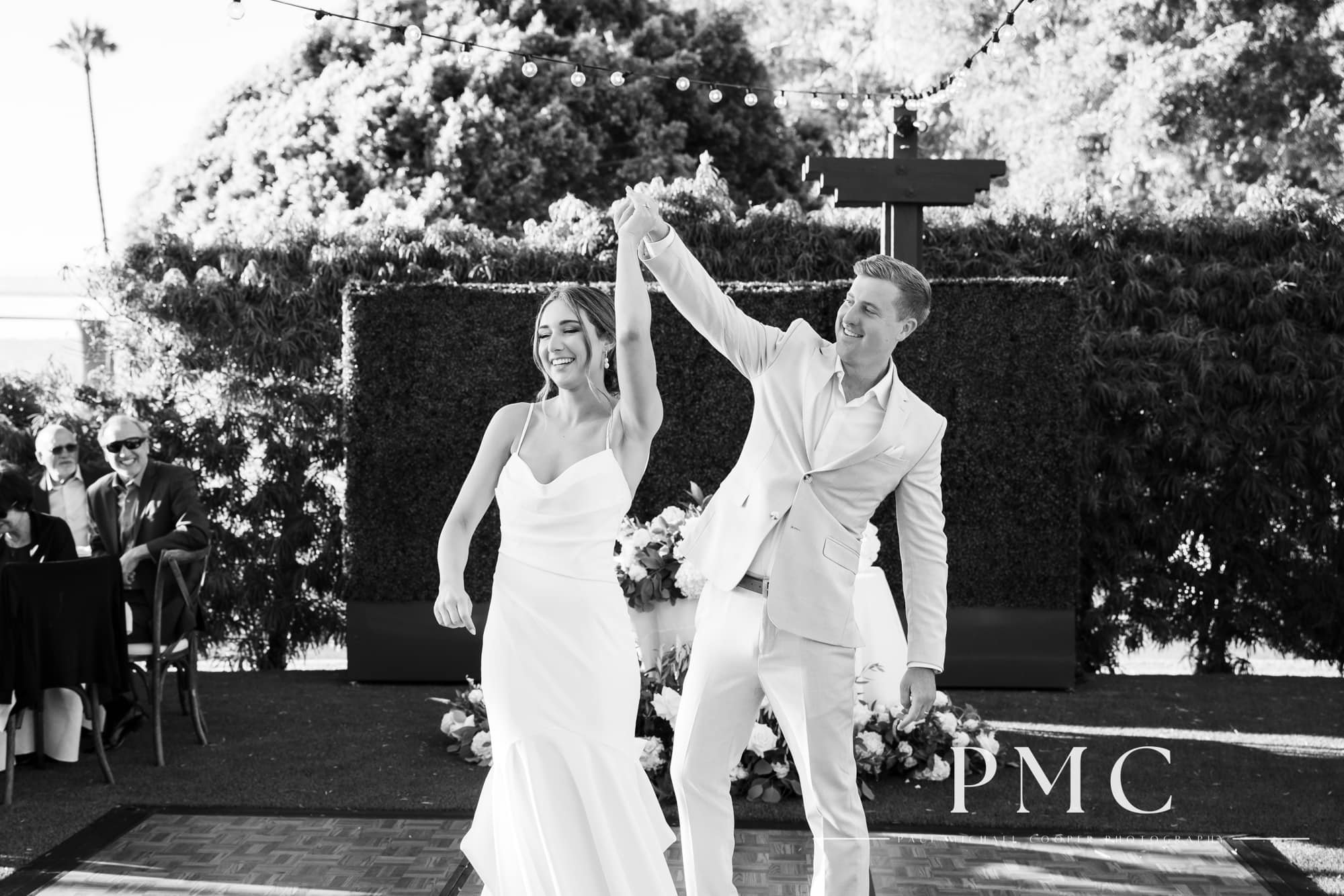 A bride and groom have their first dance at their outdoor summer wedding reception.