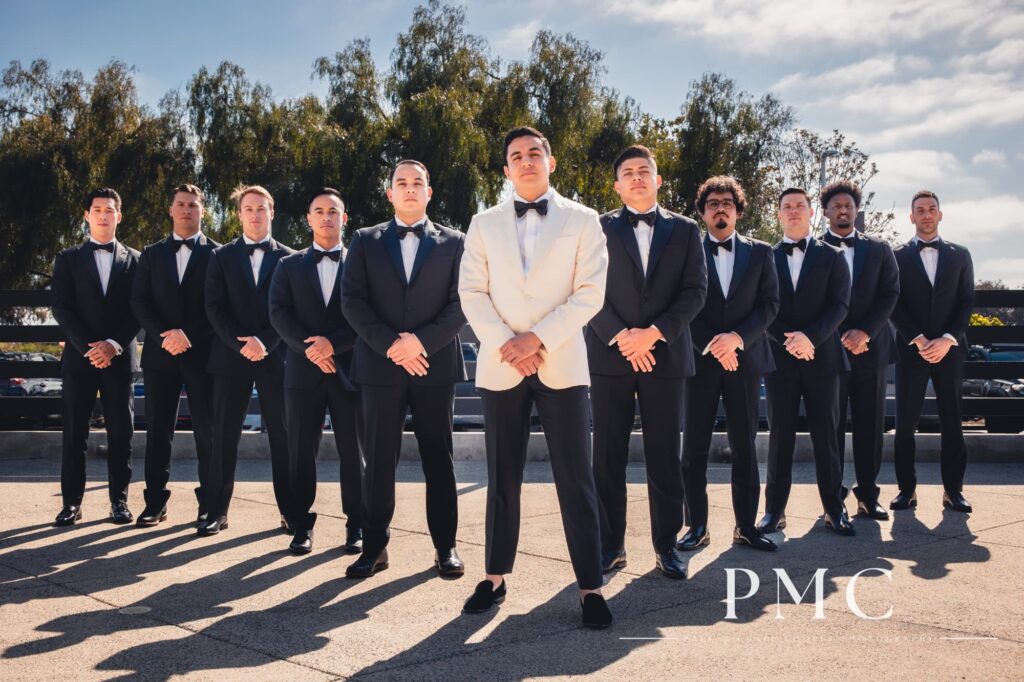 A groom poses with his groomsmen on his spring wedding day.