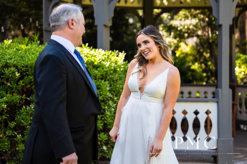 A bride smiles as she shares a First Look with her father on her spring wedding day.