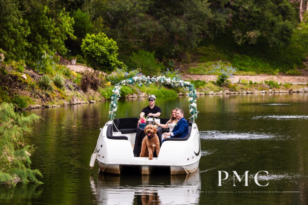 A newlywed bride and groom (and their dog) sail around the trademark lake at Los Willows Estate at their summer wedding.