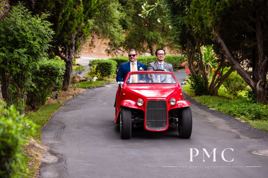 A groom and his best man enter the outdoor wedding ceremony at Los Willows in the venue's trademark red golf go-kart. 