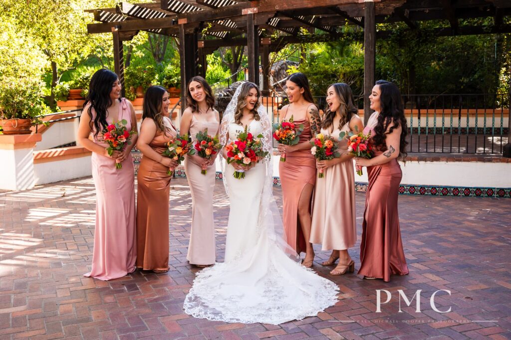 A bride and her bridesmaids smiling and laughing with each other at Rancho Las Lomas wedding venue.