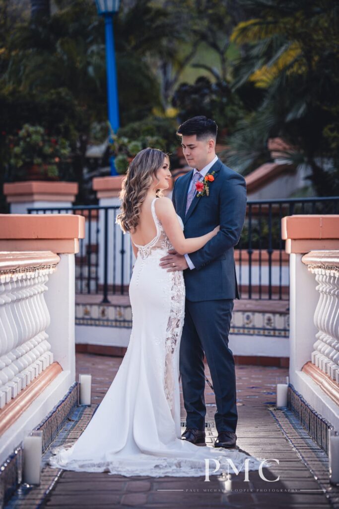 A bride and groom embrace each other on Rancho Las Lomas wedding venue's iconic bridge.