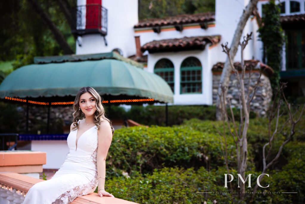 A bride poses on the railing of the signature bridge at Rancho Las Lomas wedding venue.
