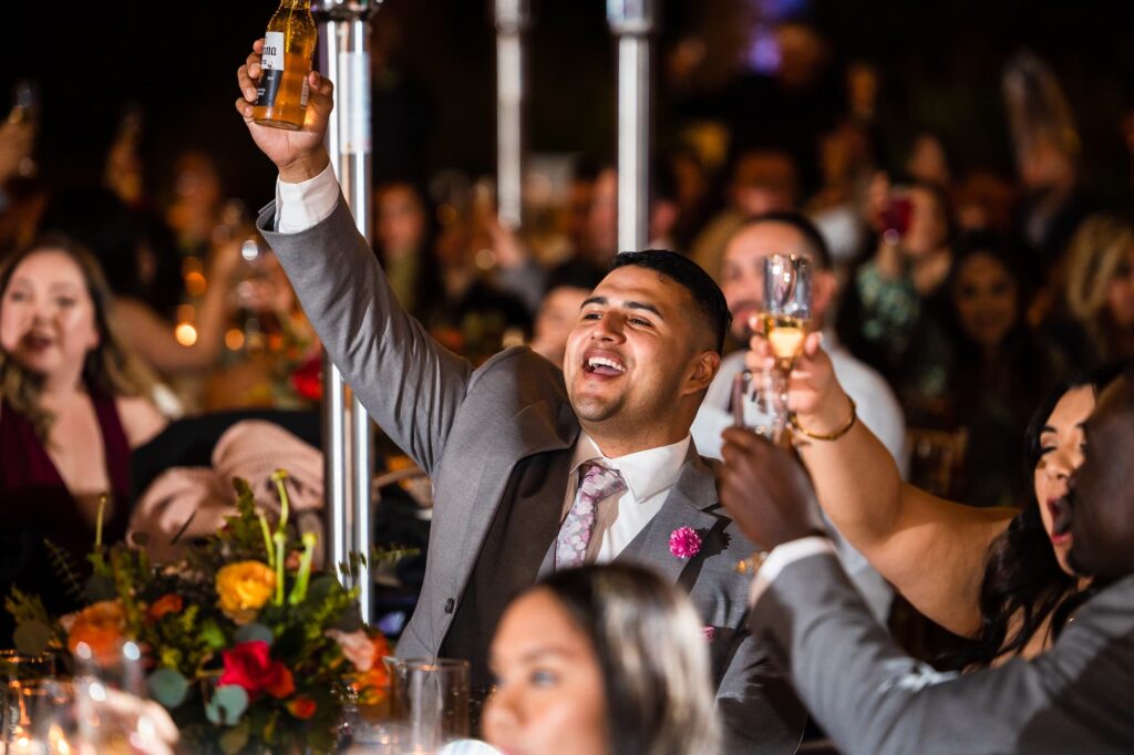 Wedding guests cheering and raising their glasses.