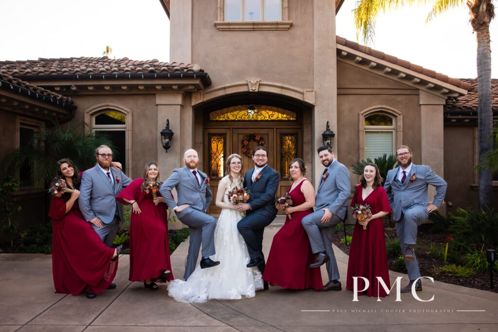 The wedding party for a fall wedding at a private Escondido estate strikes a fun pose.