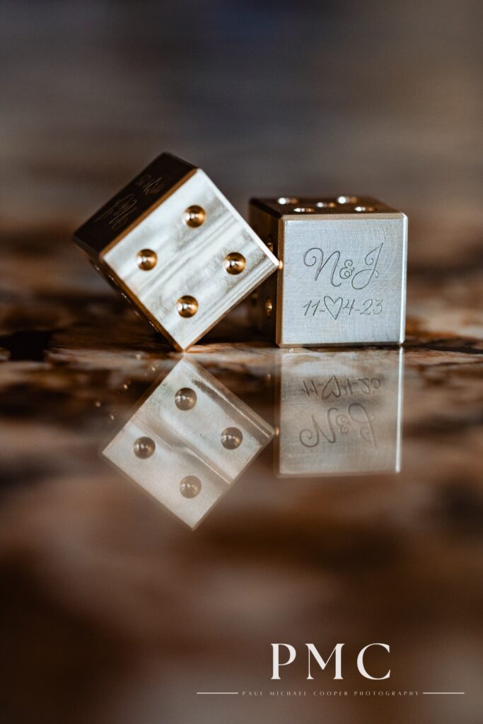 Custom gold dice engraved with the initials and wedding date, made by a friend.
