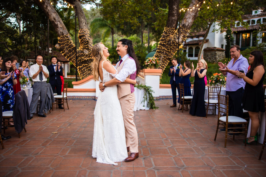 A bride and groom share their first dance in an open outdoor courtyard at their wedding reception at Rancho Las Lomas in Orange County.