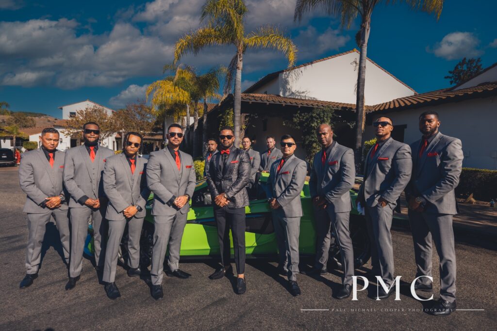A stylish groom poses with his groomsmen in front of a bright green McLaren wedding car.