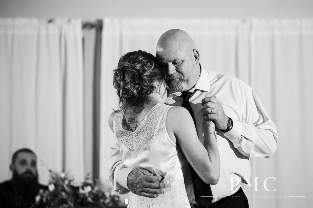 The bride and and the father of the bride share a tender moment during their Father-Daughter Dance on her wedding day.