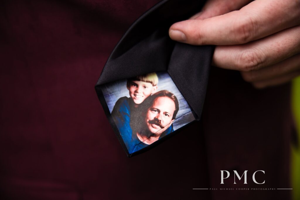 A close-up photo of the back of the groom's necktie, which has been customized with a photo of the groom as a child with his now-deceased father.