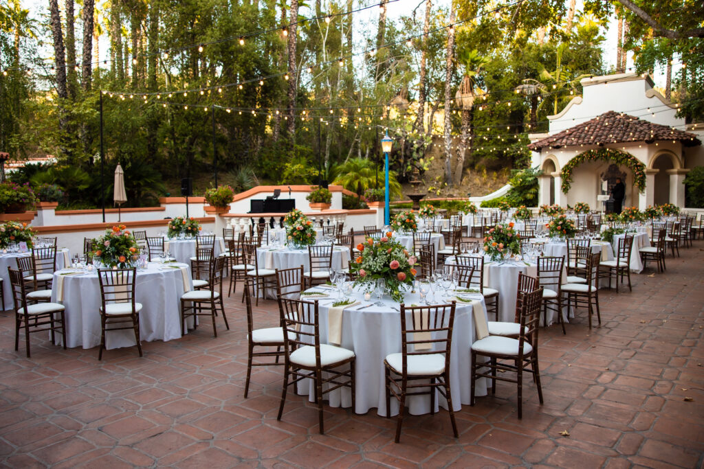 Round tables, chairs, linens, and florals all set up for an outdoor wedding reception at Rancho Las Lomas in Orange County.