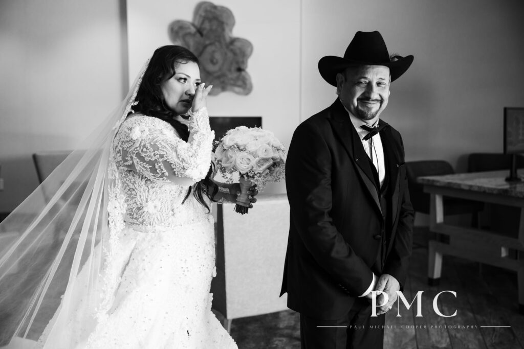 A bride tears up as she approaches her father for their wedding day First Look.