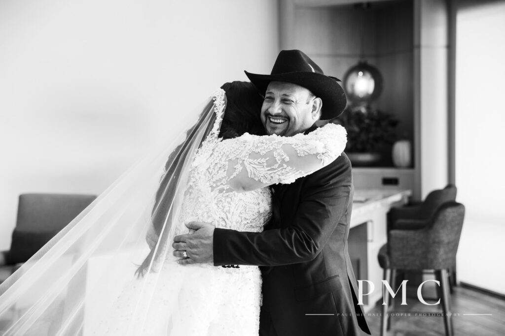 A bride and her father smile and hug each other during their special First Look.