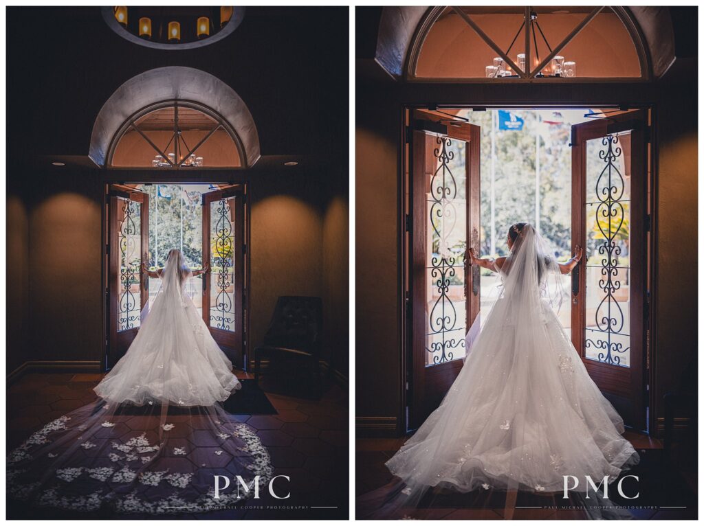 Dramatic portrait of a bride in a floor-length train and veil pushes open the main doors at The Heights Golf Course.