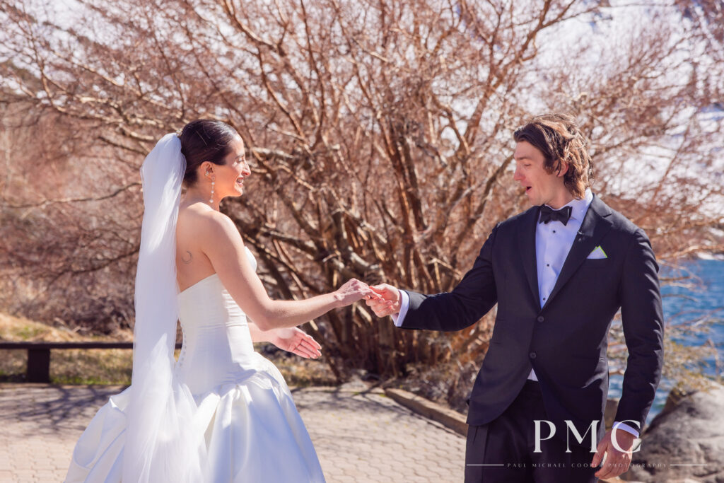 A groom looks in awe at his bride with a flowing veil during their First Look at Convict Lake in Mammoth Lakes.