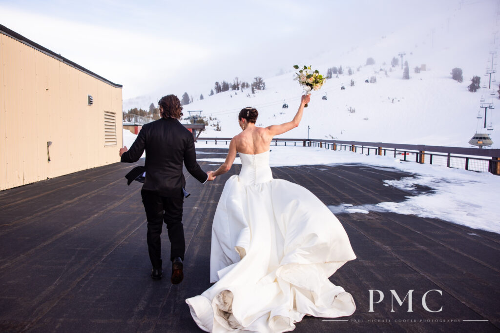 A bride and groom dance and celebrate as they exit their rooftop mountain wedding ceremony in Mammoth Lakes.