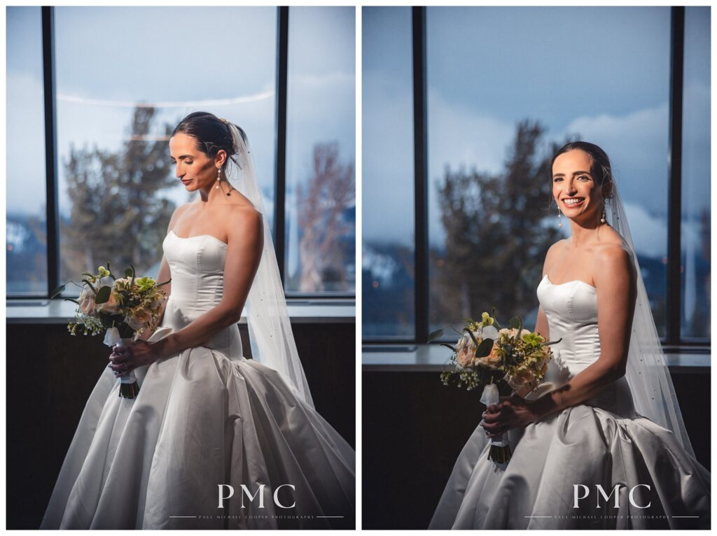 Portraits of a bride holding her bouquet in her classic dress with a sweeping veil in front of a window with a mountain view behind her.