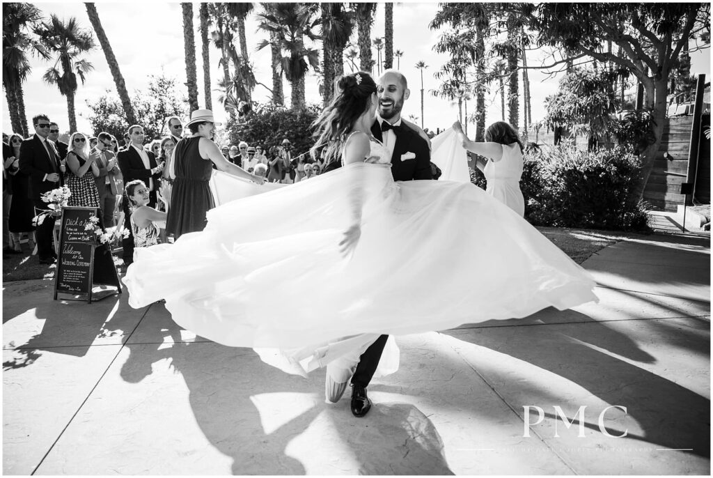 A groom lifts his bride and spins her around.