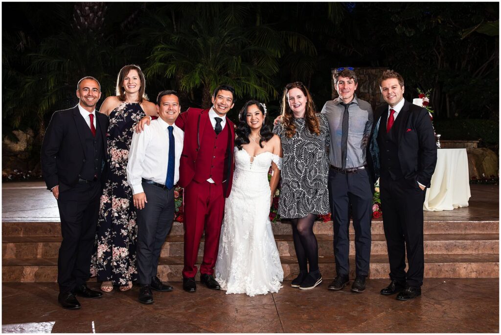 Guests at a fall wedding wearing cocktail attire and posing with the bride and groom.