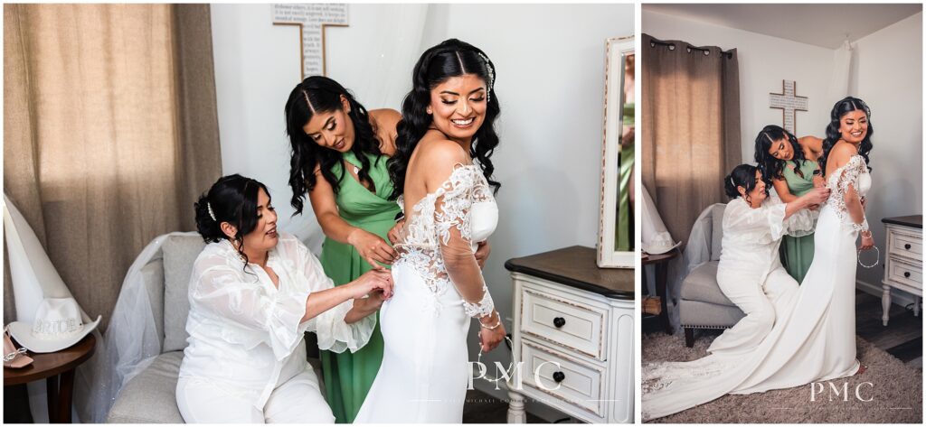 A bride is helped into her dress by her sister and mother.