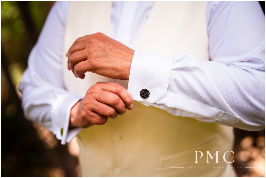 A bride wearing bespoke, monogrammed cufflinks gets ready on her summer wedding day in Vista.