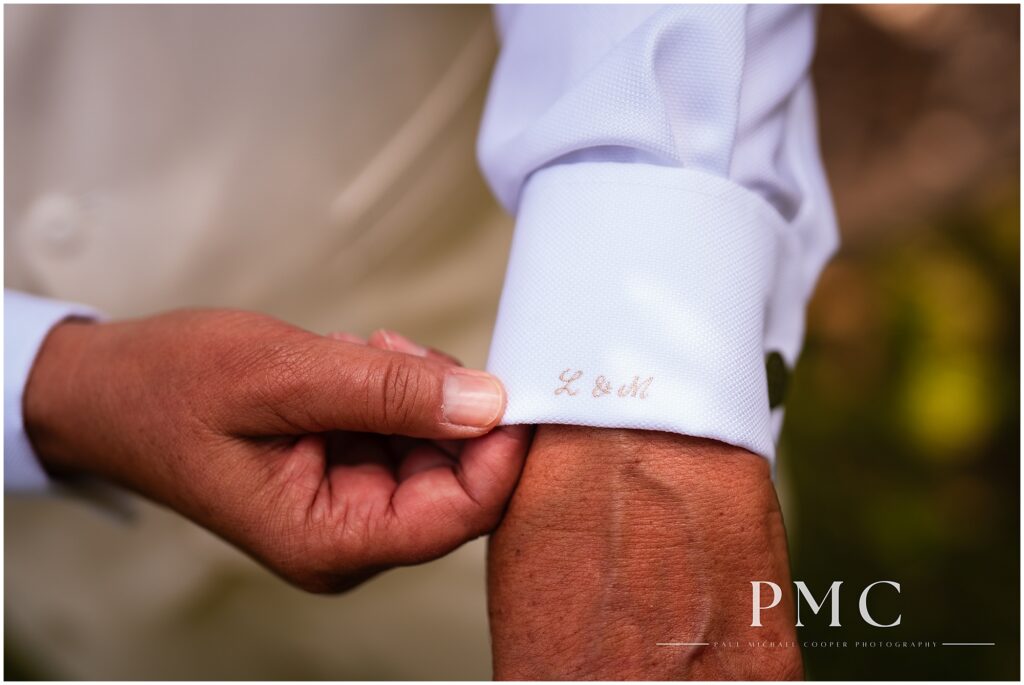 A bride wearing a bespoke, monogrammed suit gets ready on her summer wedding day in Vista.