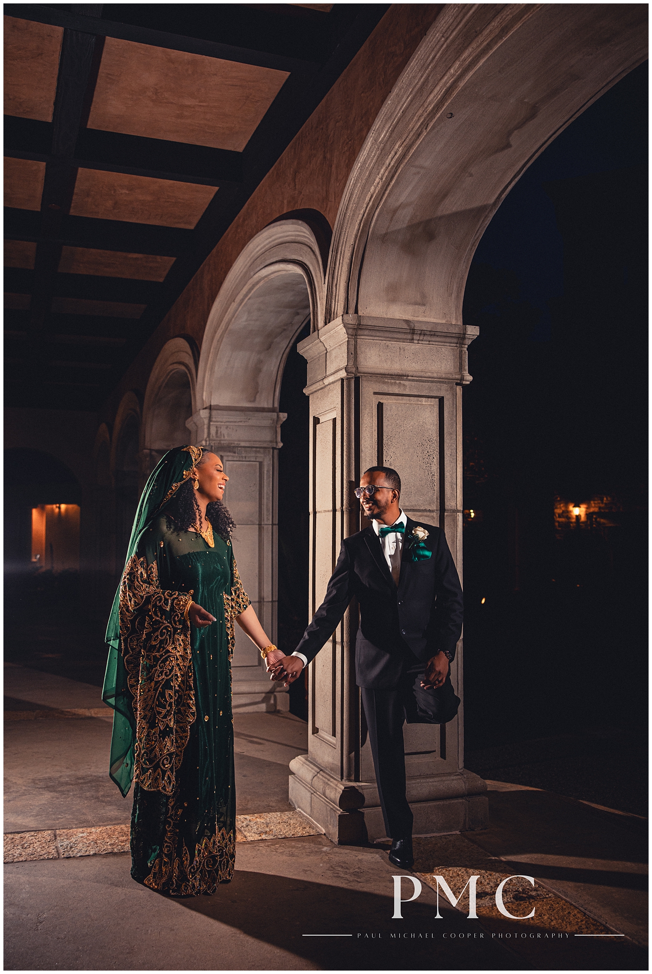 A Nigerian bride and groom smile at each other in a night portrait on their wedding day.