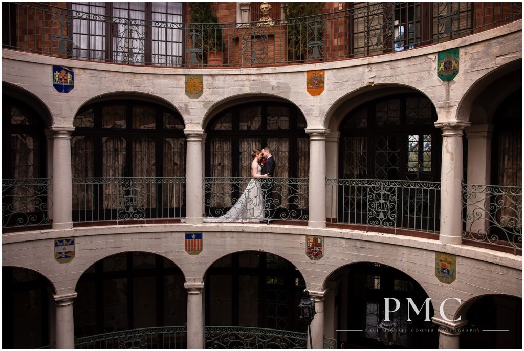 A bride and groom share a sweet embrace surrounded by the beautiful architecture of the Mission Inn's Rotunda.