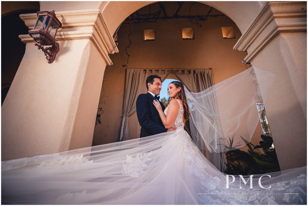 A bride and groom embrace in a dramatic, cinematic portrait at Talega Golf Club in San Clemente, Southern California on their summer wedding day.