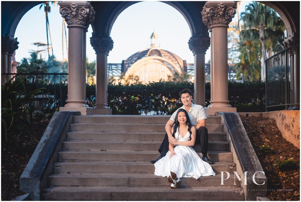 A couple in white takes autumn engagement photos at Balboa Park in the morning.