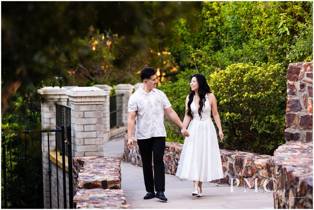 A couple in white takes autumn engagement photos at Balboa Park in the morning.