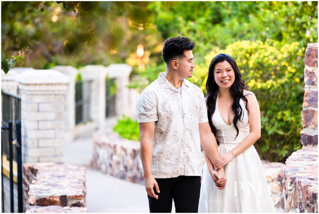 A couple in white takes autumn engagement photos at Balboa Park in the morning.