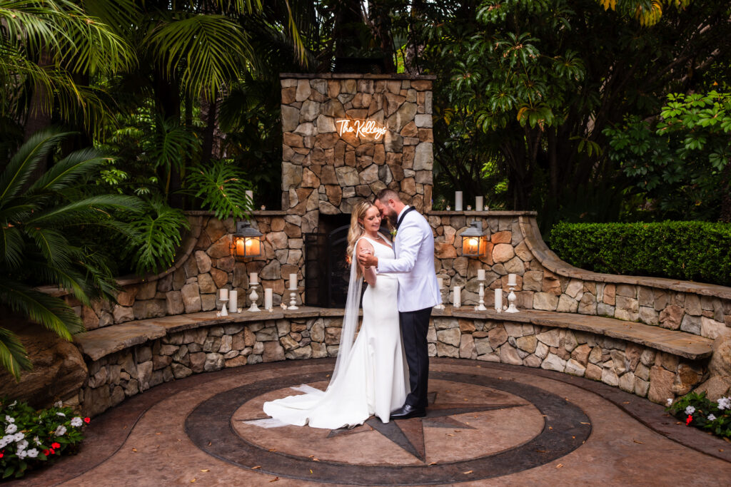 Bride and groom sharing a first dance by a stone fireplace at Grand Tradition Estate, a San Diego wedding venue.